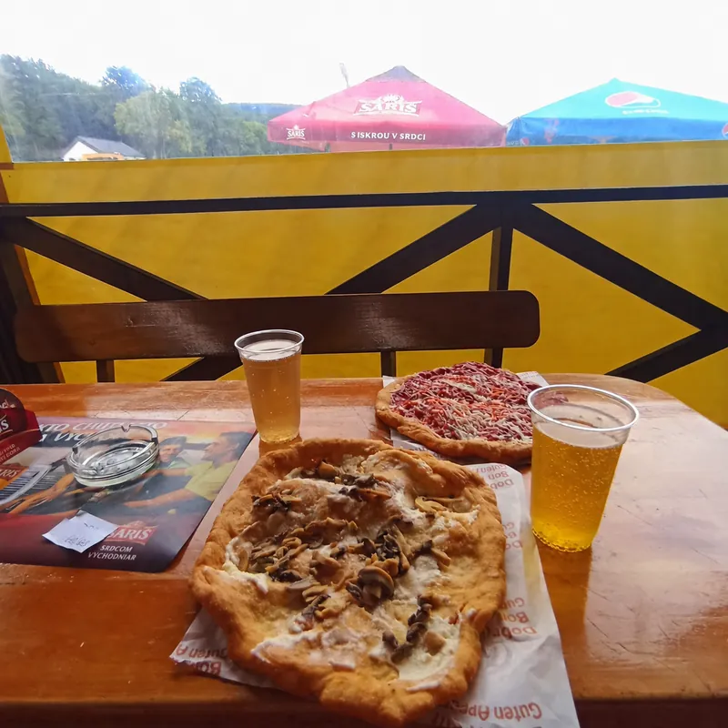 Obložené langoše a pivo na stole na terase bistra